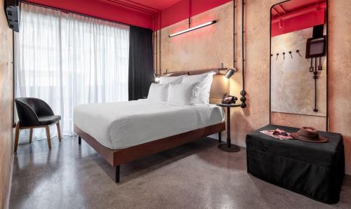 アテネにあるDave Red Athens, a member of Brown Hotelsのベッドと椅子付きのホテルルーム