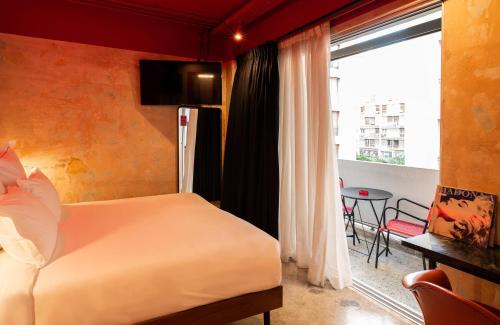 a bedroom with a bed and a window and a table at Dave Red Athens, a member of Brown Hotels in Athens