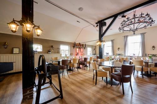 a restaurant with tables and chairs in a room at Glamping Nieuw Heeten in Nieuw-Heeten