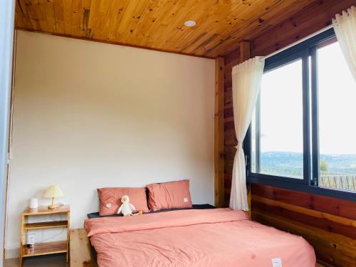 a bedroom with a bed and a large window at Lam Nguyên Charming House in Bao Loc