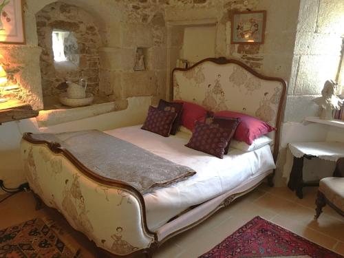 a bedroom with a large bed with pillows on it at Chateau Mareuil in Brigueuil-le-Chantre
