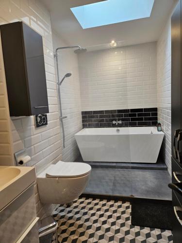 a bathroom with a tub and a toilet and a sink at Maison typique bordelaise in Bordeaux
