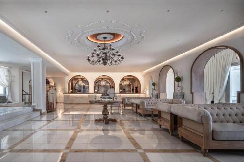 un gran vestíbulo con sillas y una lámpara de araña en Saint John Hotel Villas & Spa en Agios Ioannis Mykonos