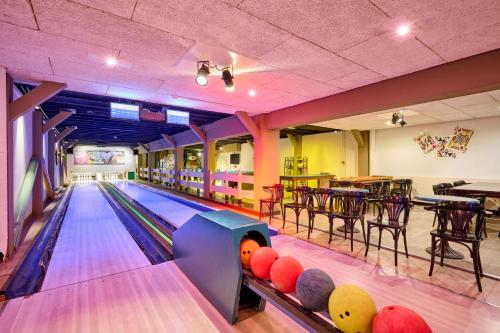 a bowling alley with pins and tables in a restaurant at Glamping Nieuw Heeten in Nieuw-Heeten