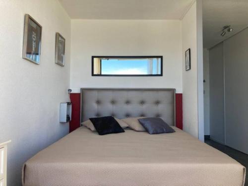 une chambre avec un grand lit avec deux oreillers dessus dans l'établissement Studio 2, Héliopolis D au village naturiste, au Cap d'Agde