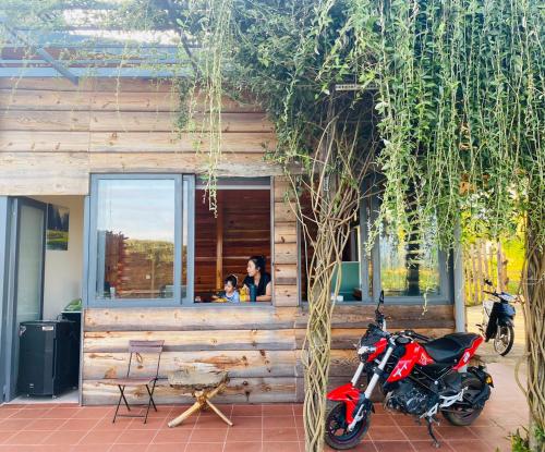 a red motorcycle parked in front of a building at Lam Nguyên Charming House in Bao Loc