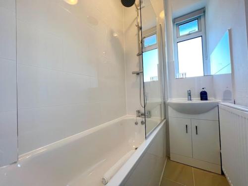 a bathroom with a tub and a sink and a shower at 2 Bed- Belsize Park in London