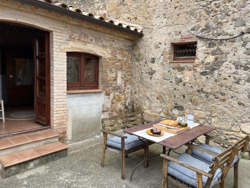 einen Tisch und Stühle vor einem Steingebäude in der Unterkunft Can LLorens in Llagostera