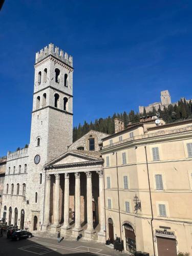 a building with a clock tower next to a building at B&B La Terrazza Del Subasio in Assisi