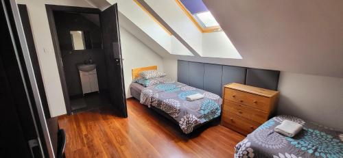 a small bedroom with two beds and a dresser at M Hostel in Gliwice