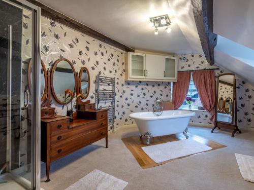 a bathroom with a tub and a sink and mirror at 9 Bed in Welshpool 40870 in Llanfyllin