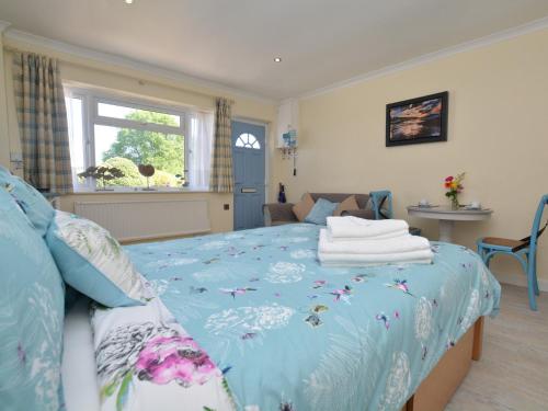 a bedroom with a blue bed with towels on it at 1 Bed in Charmouth 41890 in Charmouth