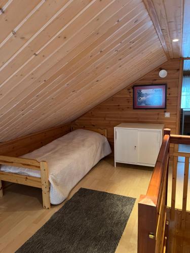 1 dormitorio en una cabaña de madera con 1 cama y TV en Holiday home with lake view and next to National Park, en Kolinkylä