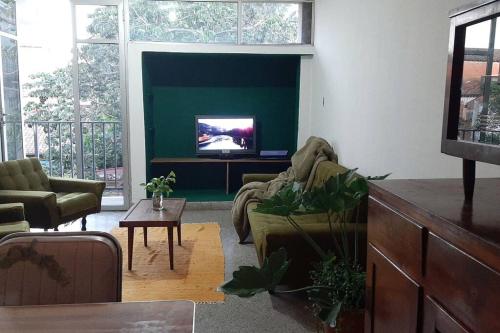 sala de estar con sofá y TV en Departamento céntrico, en San Lorenzo