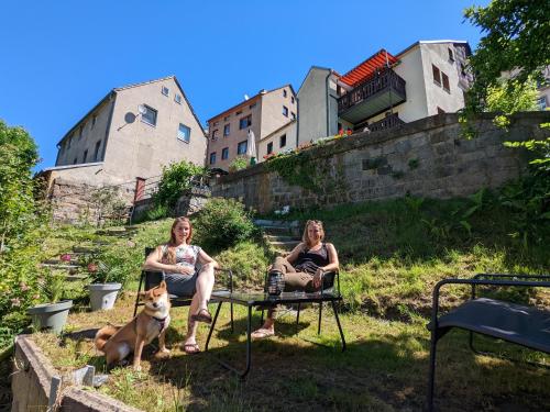 two women sitting on a bench with a dog at Zi2 - Urlaubsmagie - Flussblickwohnung mit Whirl-Pool& Sauna in Sebnitz