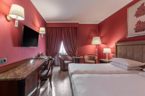 a hotel room with a bed and a sink at Doria Grand Hotel in Milan