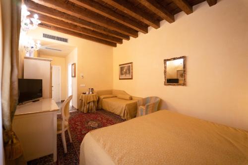 a room with two beds and a desk and a television at Alla Vigna - Room Only in Venice