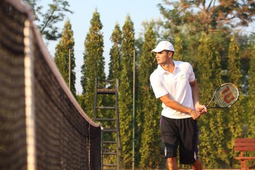 a man holding a tennis racket on a court at Hotel Danubia Park in Veliko Gradište
