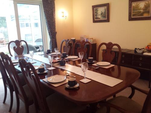 una mesa de comedor con sillas y una gran mesa de madera. en Glenade, en Bath