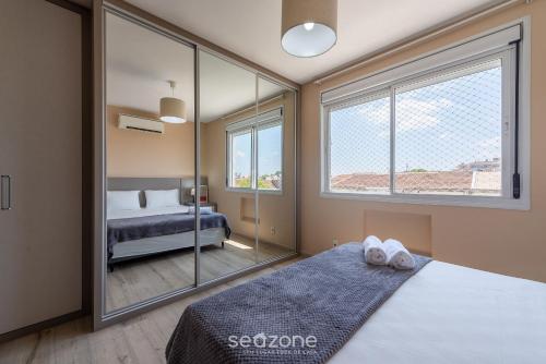a bedroom with a bed and a large window at Confortável apto em Porto Alegre/RS PRL0602 in Porto Alegre