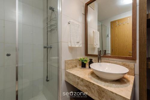 ein Bad mit einem Waschbecken und einer Dusche in der Unterkunft Confortável apto em Porto Alegre/RS PRL0602 in Porto Alegre