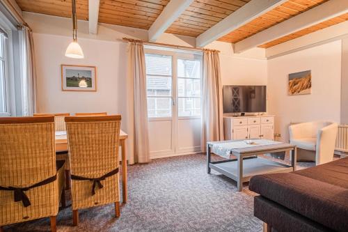 a living room with a table and a dining room at Haus Möwe in Pellworm