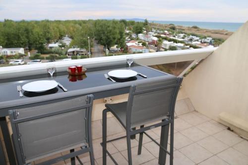 d'un balcon avec un bar et deux lunettes. dans l'établissement Studio 17, Héliopolis L au village naturiste, au Cap d'Agde