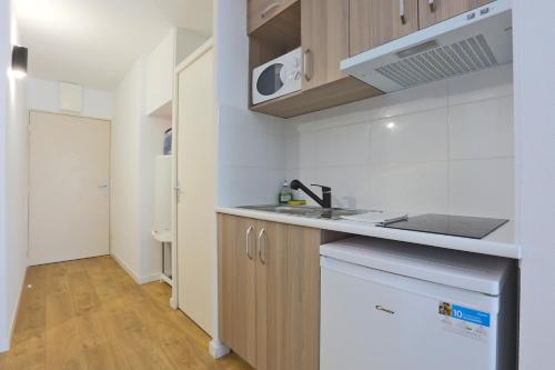 a kitchen with a sink and a counter top at KOSY Appart'Hôtels - La Maison Des Chercheurs in Vandoeuvre-lès-Nancy