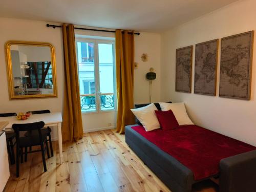 une chambre avec un lit, un bureau et une fenêtre dans l'établissement 30m2 in the heart of Paris, à Paris