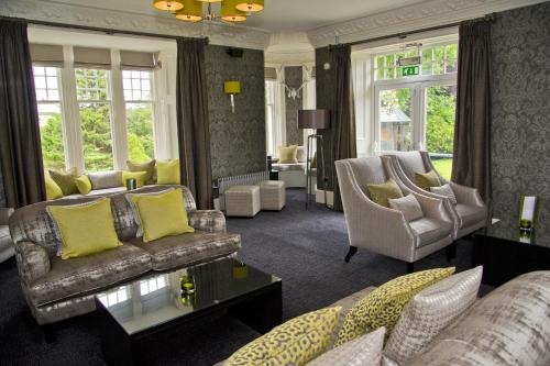 a living room with couches and chairs and windows at The Dowans Hotel of Speyside in Aberlour