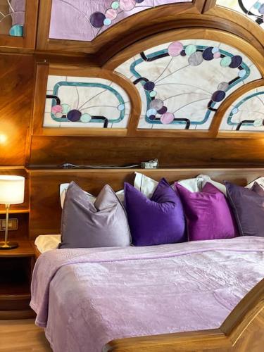 a bedroom with a bed with purple and purple pillows at Lakeside Serenity in Velden am Wörthersee