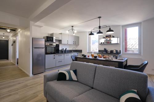 un salon avec un canapé et une cuisine dans l'établissement Magnifique*T4*centre ville*WIFI*Billard*Netflix*, à Limoux
