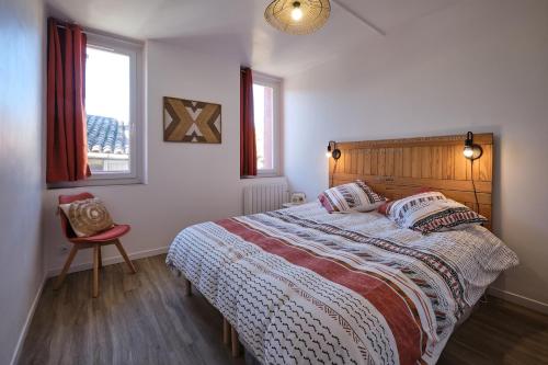a bedroom with a bed and a chair and a window at Magnifique*T4*centre ville*WIFI*Billard*Netflix* in Limoux