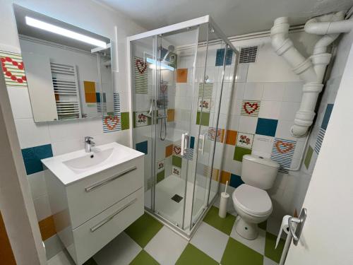 a bathroom with a shower and a toilet and a sink at Villa d'architecte - Les Pieds dans l'Eau in Ver-sur-Mer