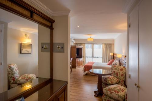 a hotel room with a bed and a table and chairs at Ayres De Salta Hotel in Salta