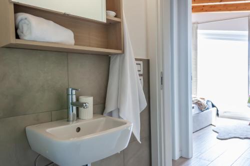 La salle de bains est pourvue d'un lavabo blanc. dans l'établissement MIA ISOLA with lake view, garden and swimming pool, à Parzanica