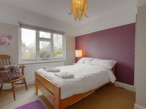 a bedroom with a large bed and a purple wall at Pass the Keys Large Family Home in Cheadle