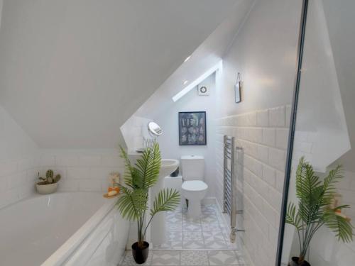 a bathroom with a tub and a toilet and a sink at Pass the Keys Large Family Home in Cheadle