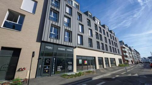 - un grand bâtiment avec des fenêtres donnant sur une rue de la ville dans l'établissement NEMEA APPART ETUD ROUEN CONSTANTINE, à Rouen