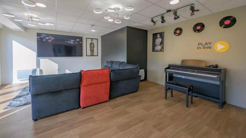 - un salon avec un canapé et un piano dans l'établissement NEMEA APPART ETUD ROUEN CONSTANTINE, à Rouen