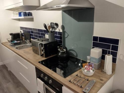 a kitchen counter with a sink and a microwave at Smart modern studio flat in central Bournemouth in Bournemouth