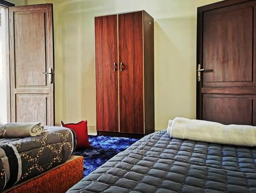 a bedroom with a large bed and a wooden cabinet at Huwari Apartments in Aqaba