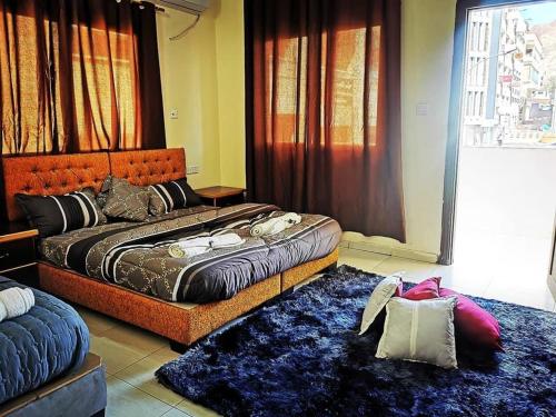 een slaapkamer met 2 bedden en 2 tapijten bij Huwari Apartments in Aqaba