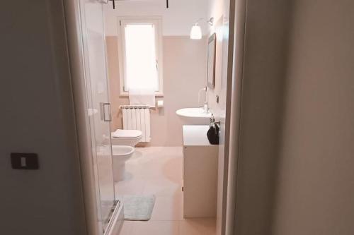uma casa de banho com 2 lavatórios, um WC e uma janela em Viale Italia centralissimo corso em Avellino