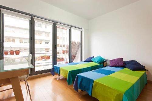 two beds in a room with a large window at Lisbon City Center Dream´s in Lisbon