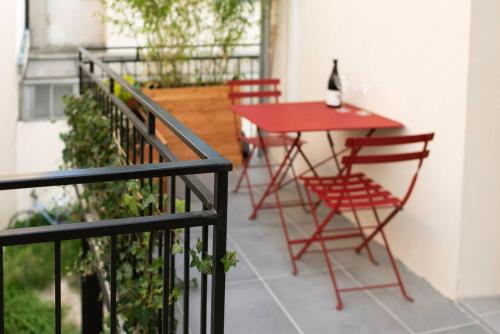 a patio with a red table and chairs on a balcony at Joli Duplex Confort T2 Paris Porte De Versailles in Vanves
