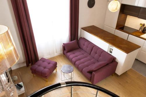 a living room with a purple couch and two stools at Joli Duplex Confort T2 Paris Porte De Versailles in Vanves