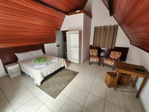a bedroom with a bed and a table and chairs at Espaço Chalé Cereja in Cachoeira Paulista