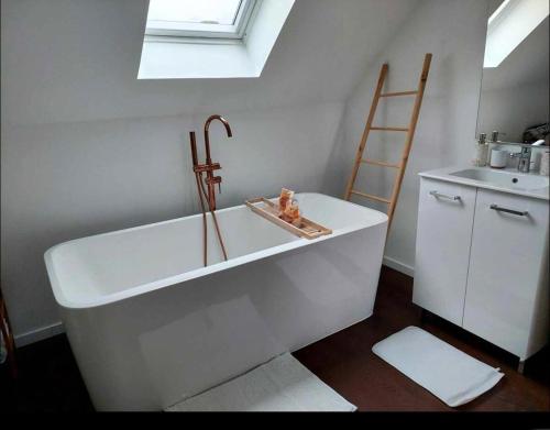 een badkamer met een bad en een wastafel bij Duplex Cosy 100m2 Terrasse Fouesnant Les Glénan in Fouesnant