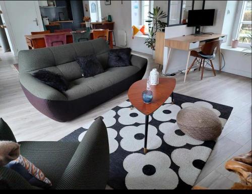 een woonkamer met een bank en een tafel bij Duplex Cosy 100m2 Terrasse Fouesnant Les Glénan in Fouesnant